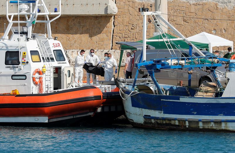 &copy; Reuters. Emergency services carry a body at the dock of Le Castella after a migrant boat caught fire during rescue operations off the coast of Crotone, with some people still missing according to Italian media