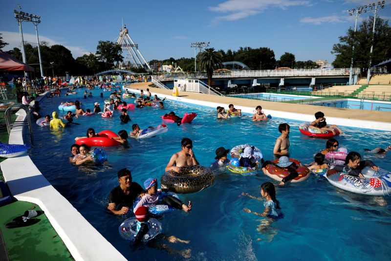 &copy; Reuters. Visitors enjoy doughnut-shaped pool, amid the coronavirus disease(COVID-19) outbreak, at Toshimaen amusement park in Tokyo