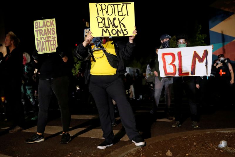 &copy; Reuters. FILE PHOTO: Demonstrators hold signs during a protest against police violence and racial injustice in Portland