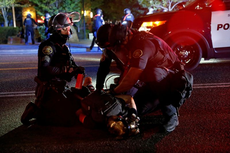 © Reuters. FILE PHOTO: Police officers detain a demonstrator during a protest against police violence and racial injustice in Portland