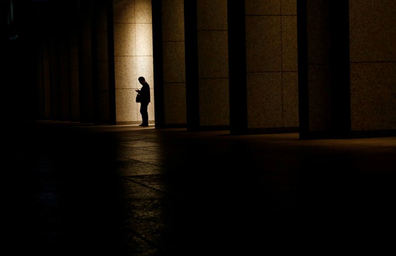 &copy; Reuters. FILE PHOTO: A man is silhouetted at an entrance of a commercial building at closing hour at a financial district in Tokyo