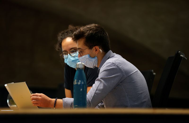 &copy; Reuters. French workers get ready to wear mandatory masks in open working spaces