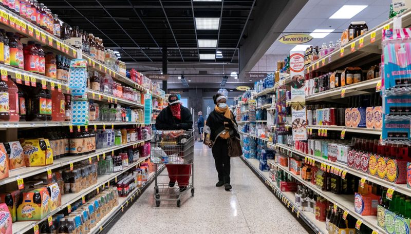 © Reuters. FILE PHOTO: Shoppers browse in a supermarket while wearing masks in St Louis