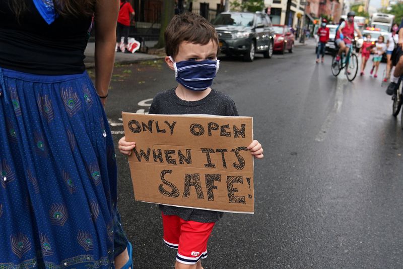 &copy; Reuters. Criança segura cartaz contra reabertura de escolas em Nova York