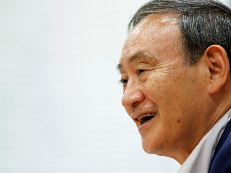 &copy; Reuters. FILE PHOTO: Japan&apos;s top government spokesman Chief Cabinet Secretary Yoshihide Suga smiles during an interview with Reuters in Tokyo