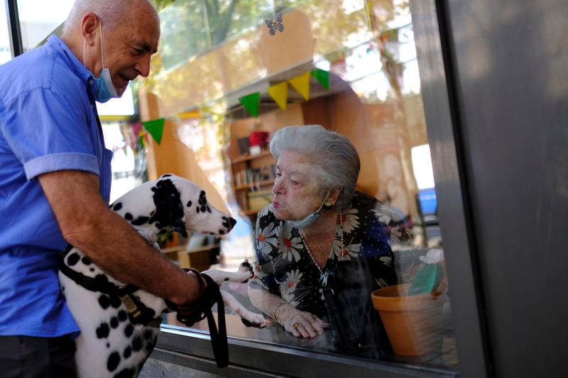 Spanish nursing home residents greet friends, family from behind windows