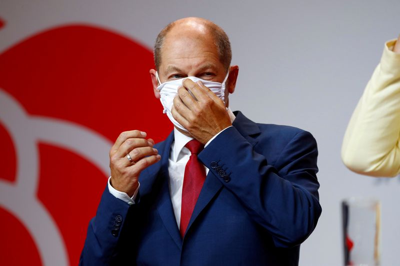 &copy; Reuters. FILE PHOTO: Olaf Scholz adjusts his protective face mask after a news conference in Berlin