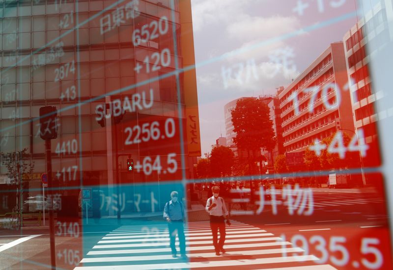 &copy; Reuters. People wearing protective masks, following the coronavirus disease (COVID-19) outbreak, are reflected on a screen showing stock prices outside a brokerage in Tokyo