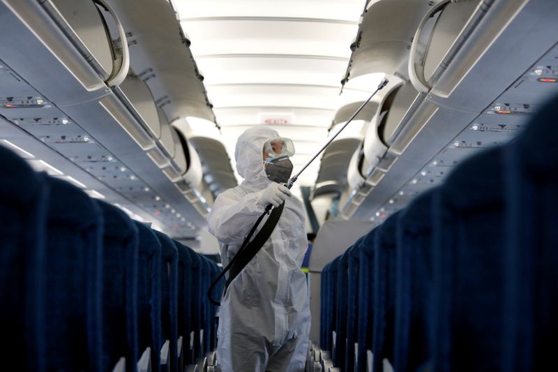 &copy; Reuters. FILE PHOTO: A health worker sprays disinfectant inside a Vietnam Airlines airplane to protect from the recent coronavirus outbreak, at Noi Bai airport in Hanoi, Vietnam