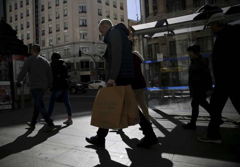 &copy; Reuters. People carry shopping bags at a shopping district in Madrid, Spain