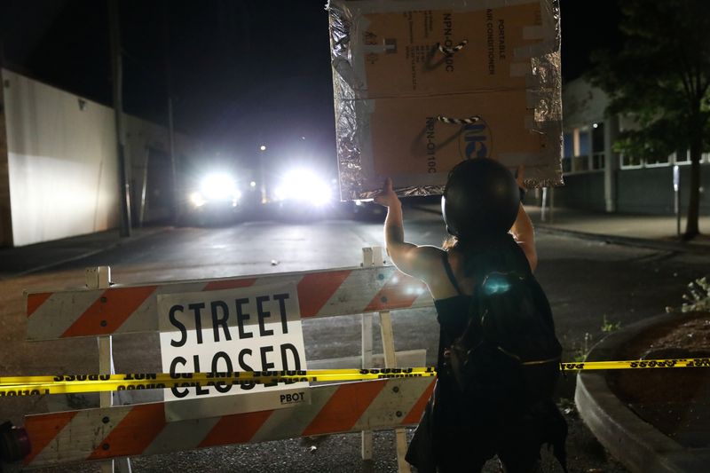 &copy; Reuters. Un manifestante se enfrenta a la policía cerca de la Oficina de Policía de Portland North Precint durante una manifestación contra la violencia policial y la desigualdad racial en Portland, Oregón, EEUU