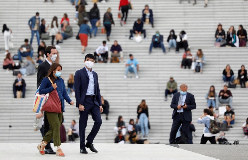 &copy; Reuters. Alcune persone con addosso una mascherina protettiva per proteggersi dal coronavirus presso il distretto finanziario La Defense di Nanterre, 1 settembre 2020