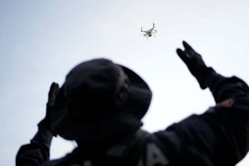 &copy; Reuters. A police officer uses a drone during a search for skeletal remains and clothing at a plot of land in the municipality of Hidalgo