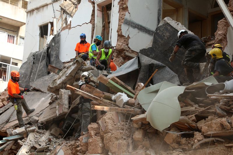 &copy; Reuters. Equipos de rescate buscan entre los escombros de edificios derrumbados por la enorme explosión en el área portuaria de  Beirut