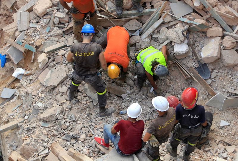 &copy; Reuters. Rescue team members search through rubble of buildings damaged due to the massive explosion in Beirut