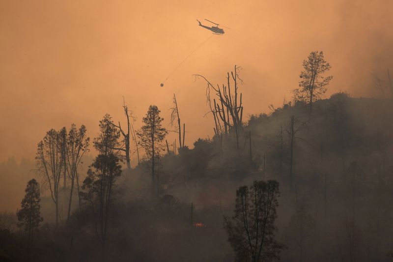 © Reuters. FOTO DE ARCHIVO: FOTO DE ARCHIVO: Helicóptero libera agua cuando el incendio del Complejo Relámpago LNU se desconecta cerca de Middletown, California