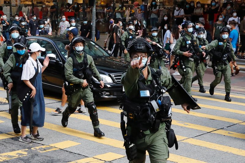 © Reuters. Riot police chase pro-democracy protesters during a demonstration oppose postponed elections, in Hong Kong