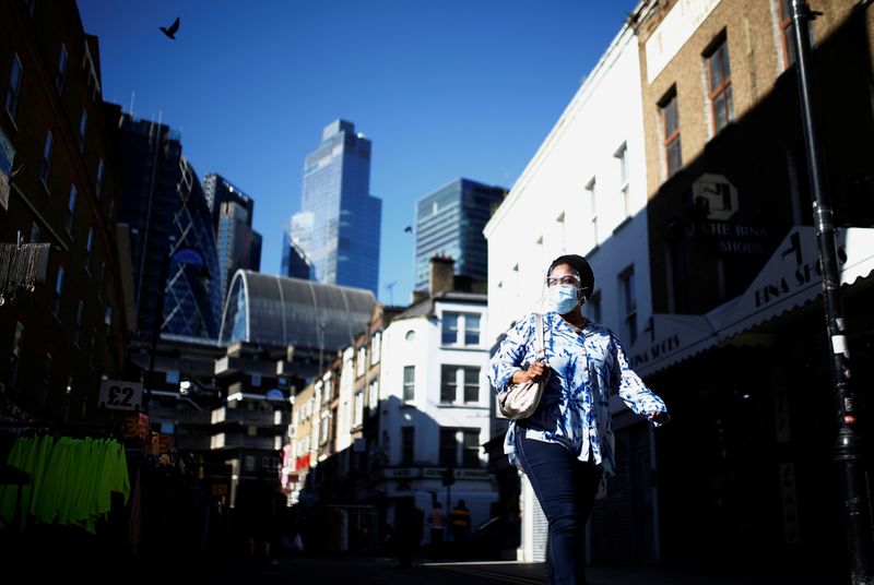 &copy; Reuters. A woman wearing a protective face mask walks along the Petticoat Lane Market, amid the coronavirus disease (COVID-19) outbreak, in London