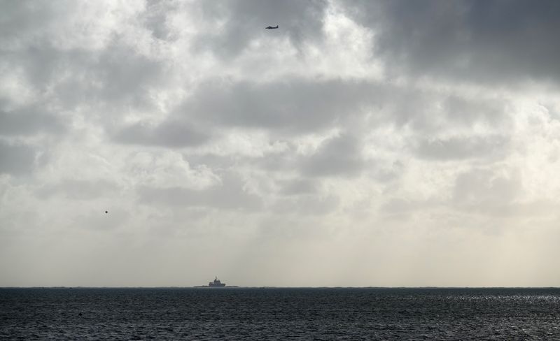 &copy; Reuters. A general view shows a coastguard search and rescue helicopter hovering near the scene where a tugboat involved in cleaning up an oil spill off from MV Wakashio, collided with a barge during bad weather, in Powder d&apos;Or