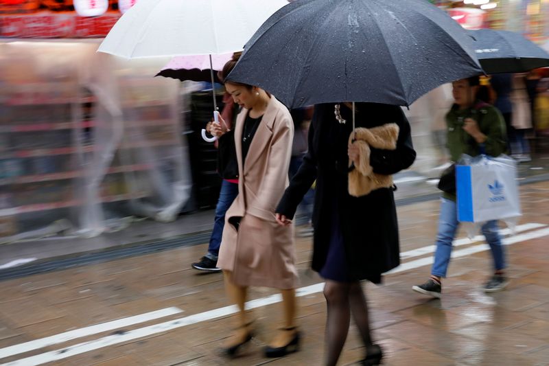 &copy; Reuters. FILE PHOTO:  Shoppers walk through the rain in an Osaka shopping district