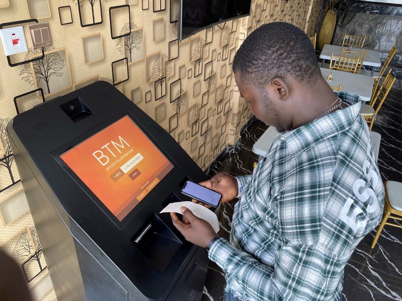 &copy; Reuters. A bitcoin user checks the receipts after buying bitcoins with naira on Bitcoin Teller Machine in Lagos