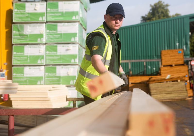 &copy; Reuters. File photo of a worker stacking timber at the Vauxhall depot of building material supplier Travis Perkins in London