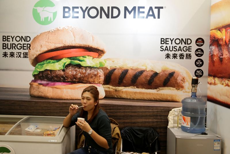 &copy; Reuters. A woman sits next to a poster at the booth of plant-based food company Beyond Meat at VeggieWorld fair in Beijing