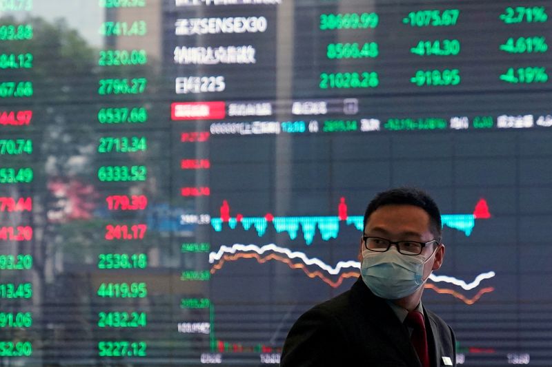 &copy; Reuters. Un uomo con indosso la mascherina fotografato all&apos;interno della sede della Borsa di Shanghai