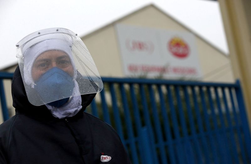 &copy; Reuters. Funcionário de unidade da JBS com máscara e protetor facial após empresa ser atingida por surto de coronavírus, em Passo Fundo (RS)