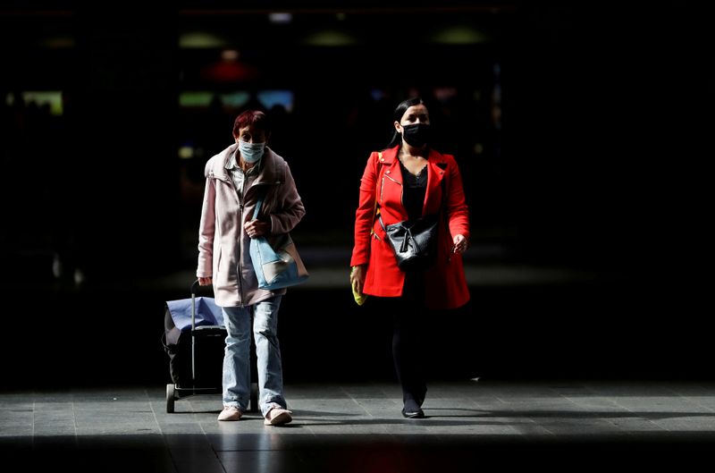 &copy; Reuters. FILE PHOTO: Passengers wearing protective masks walk at Prague&apos;s main railway station