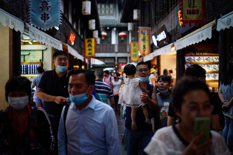 &copy; Reuters. People wearing face masks walk on Jinli Ancient Street in Chengdu