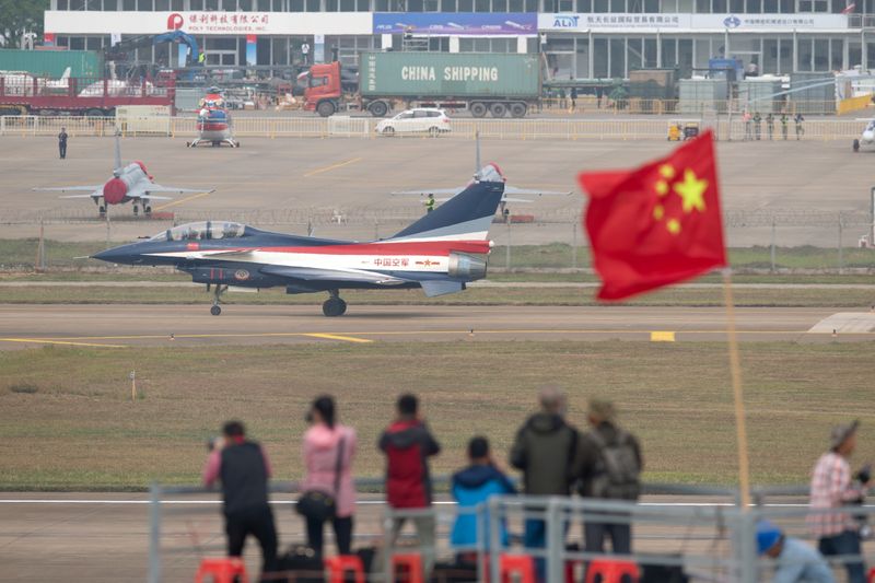 &copy; Reuters. People take photos of aircraft of Chinese People&apos;s Liberation Army Air Force (PLAAF)&apos;s Bayi Aerobatic Team during a test flight ahead of Zhuhai Airshow