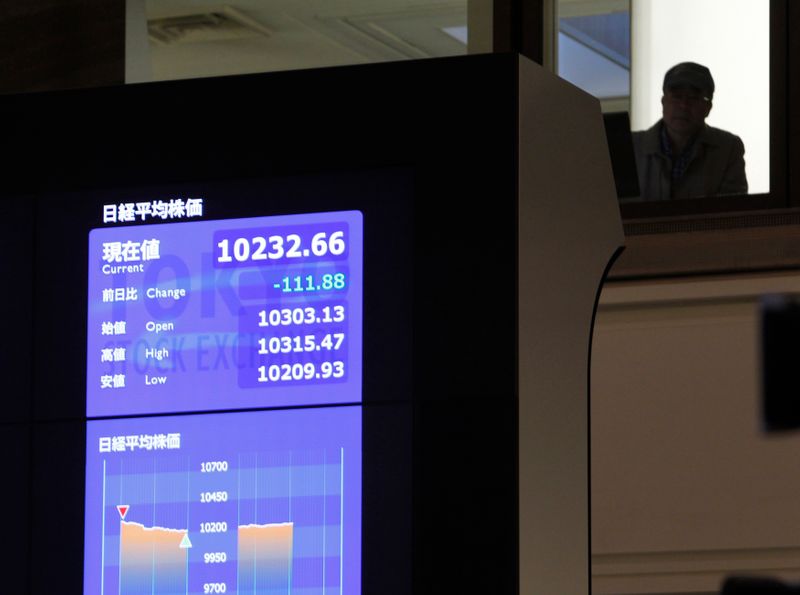 &copy; Reuters. Un visitatore all&apos;interno della sede della Borsa di Tokyo, dietro a uno schermo che mostra l&apos;andamento dell&apos;indice Nikkei