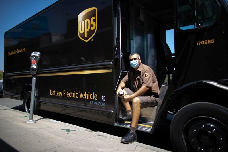 &copy; Reuters. UPS Driver Gilbert Lopez poses with his electric UPS truck, amid the global outbreak of the coronavirus disease (COVID-19), in Los Angeles