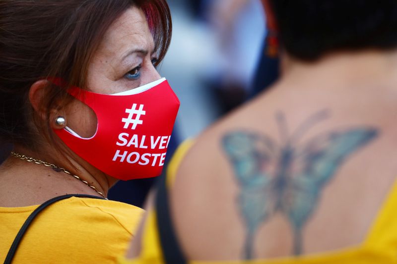 &copy; Reuters. A demonstrator wears protective face masks reading &quot;Save the hostelry sector&quot; as she attends a protest in Madrid