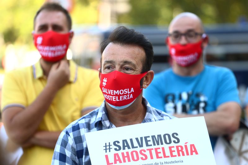 &copy; Reuters. Demonstrators wear protective face masks reading &quot;Save the hostelry sector&quot; as they attend a protest in Madrid