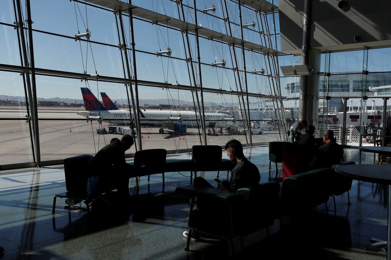 &copy; Reuters. Travelers sit in a lounge area as Delta Air Lines plane park at a gate in McCarran International Airport in Las Vegas