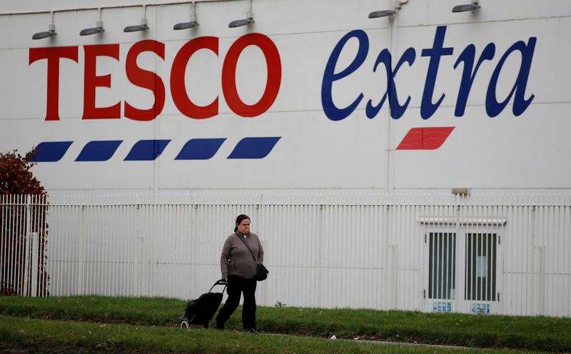 © Reuters. FILE PHOTO: A woman walks past a Tesco extra superstore near Manchester