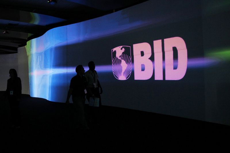 &copy; Reuters. FILE PHOTO: Visitors walk past a screen with the logo of Banco Interamericano de Desarrollo at the Atlapa Convention Center in Panama City