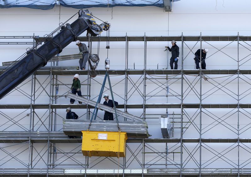 &copy; Reuters. FILE PHOTO: Men work near a crane at a construction site in Tokyo