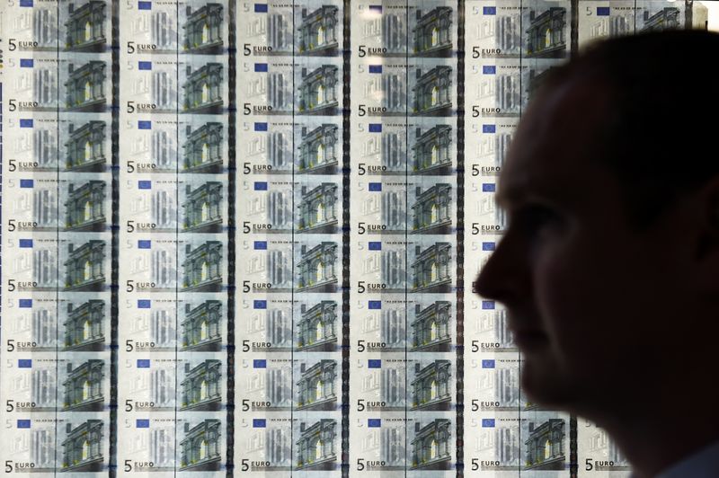 &copy; Reuters. A man is seen in front of a sheet of five Euro notes at the opening of the new Central Bank of Ireland offices in Dublin