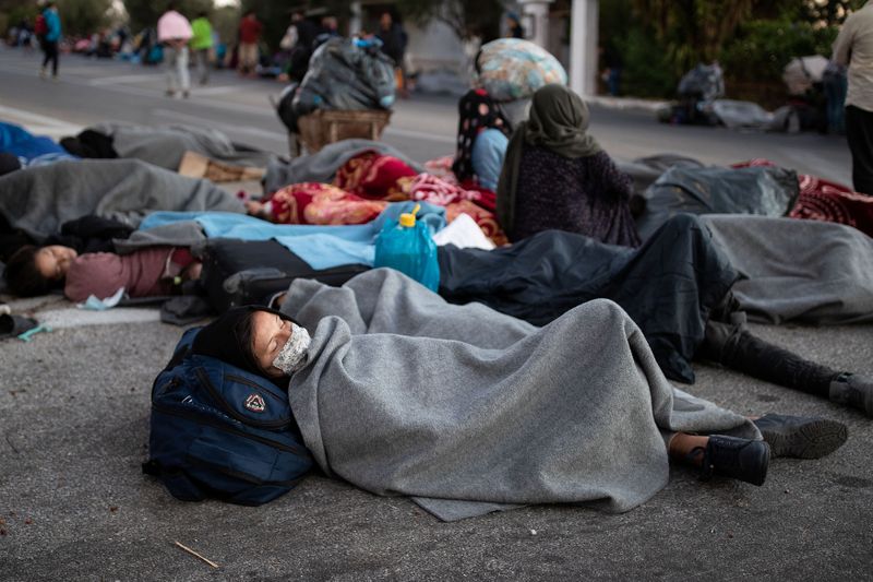 © Reuters. Refugees and migrants sleep on a road following a fire at the Moria camp on the island of Lesbos