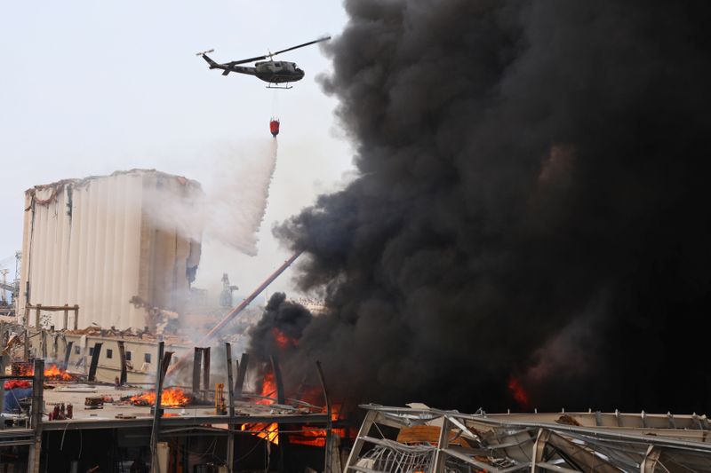 &copy; Reuters. Un helicóptero intenta apagar el incendio desatado en la zona del puerto de Beirut, Líbano