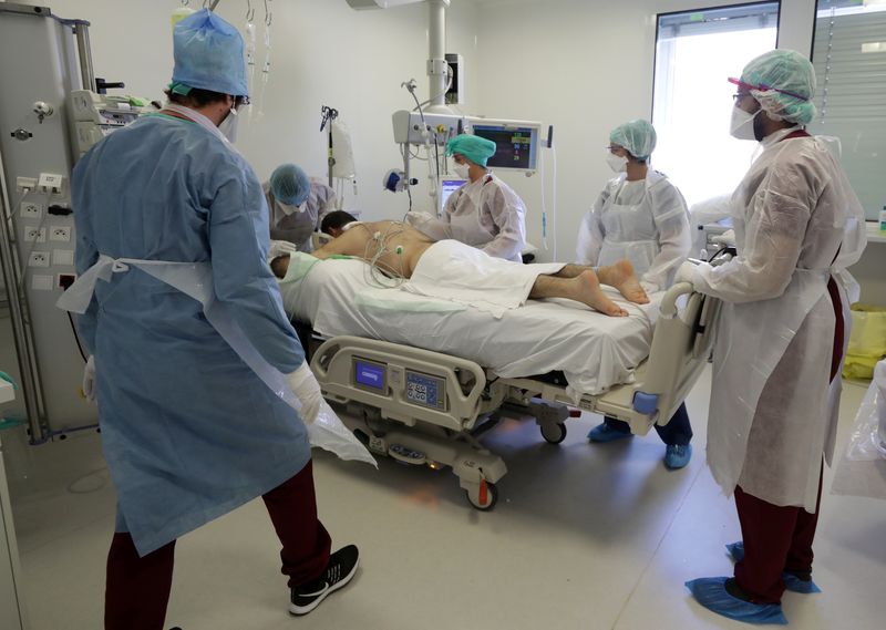 &copy; Reuters. Profissionais de saúde com trajes de proteção tratam de paciente com Covid-19 em hospital de Marselha, na França