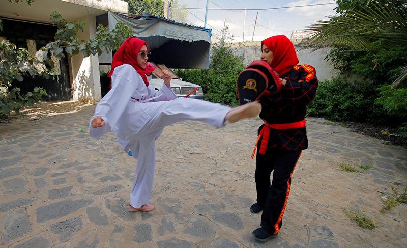 &copy; Reuters. La entrenadora de artes marciales Seham Amer practica movimientos de defensa personal con una estudiante en una casa en Saná