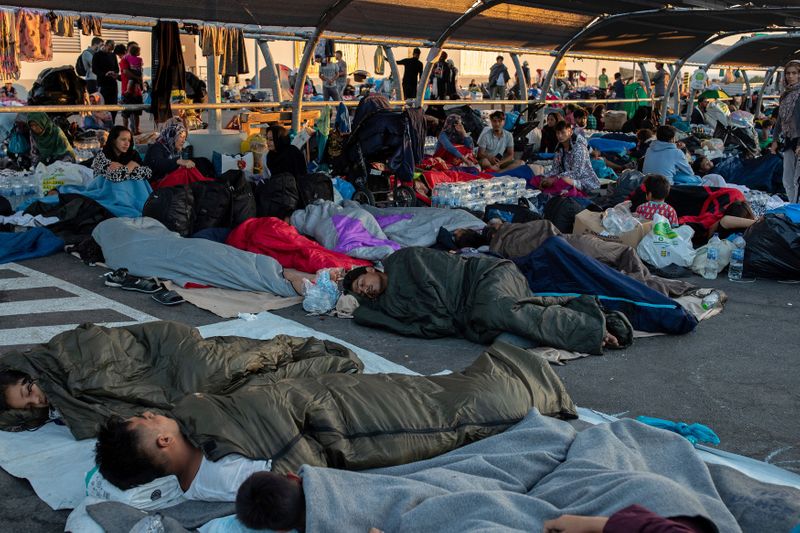 &copy; Reuters. Refugees and migrants sleep at the parking of a supermarket, following a fire at the Moria camp on the island of Lesbos