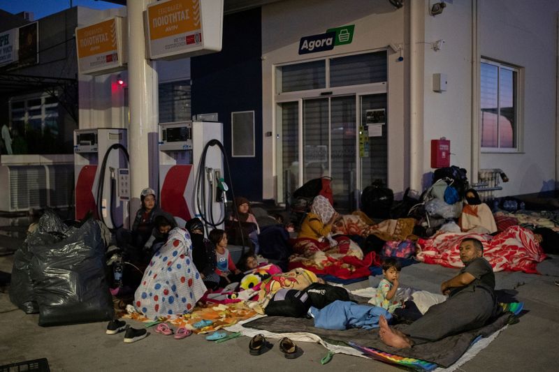 &copy; Reuters. Refugees and migrants find shelter outside a gas station, following a fire at the Moria camp on the island of Lesbos