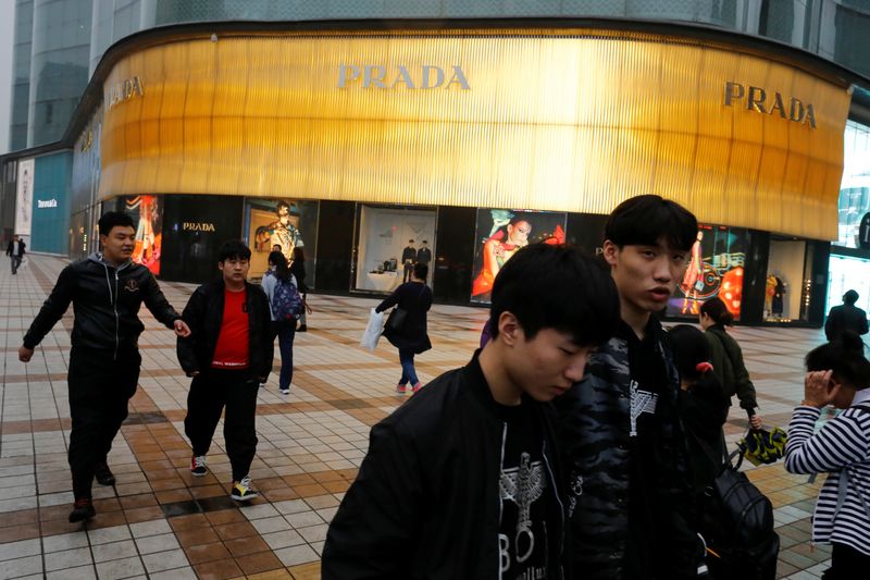&copy; Reuters. FILE PHOTO: People walk past a Prada luxury fashion boutique near Wangfujing Street
