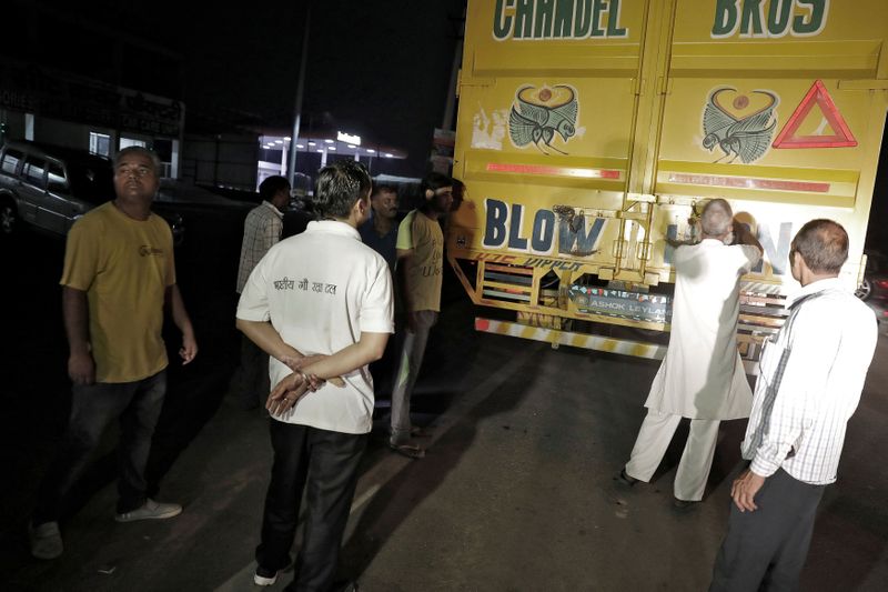 &copy; Reuters. FILE PHOTO: A Muslim driver prepares to show cow vigilantes the contents of his truck at a road block near Chandigarh