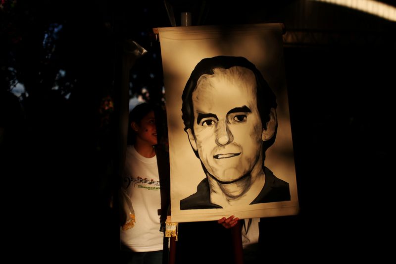 © Reuters. FILE PHOTO: Students hold a portrait of Jesuit priest Ignacio Ellacuria prior to a procession in San Salvador